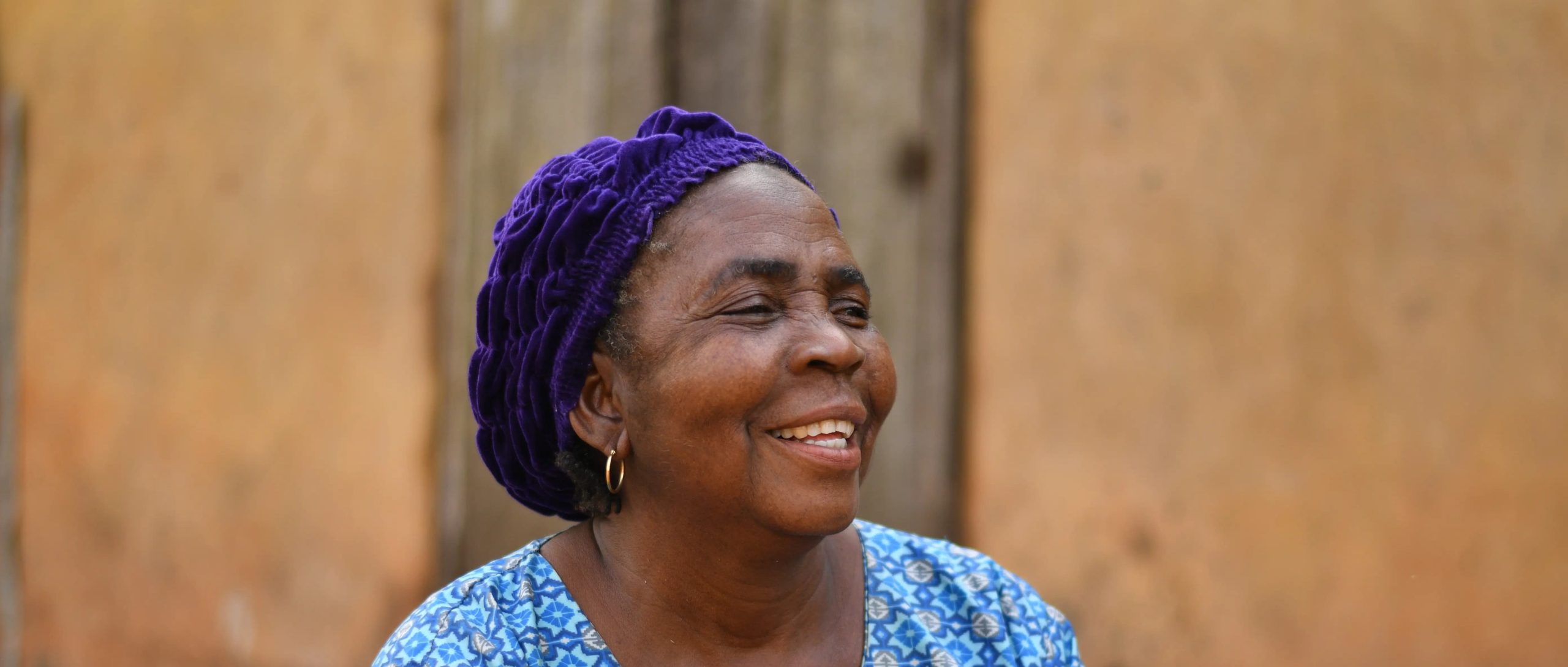 A smiling woman from the Gate of Hope community outdoors