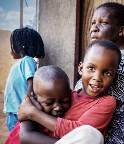 A woman and three children together outside their home in Rwanda