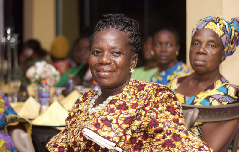 Women in vibrant traditional dress gathered together at a community celebration.