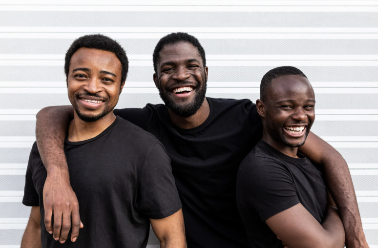 Three men standing together and smiling