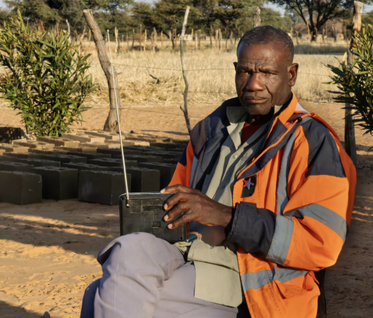 A man tending rows of young tree seedlings at a plant nursery
