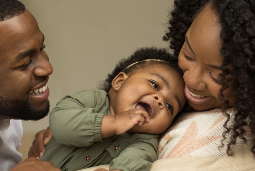 A child laughing in a loved one's arms